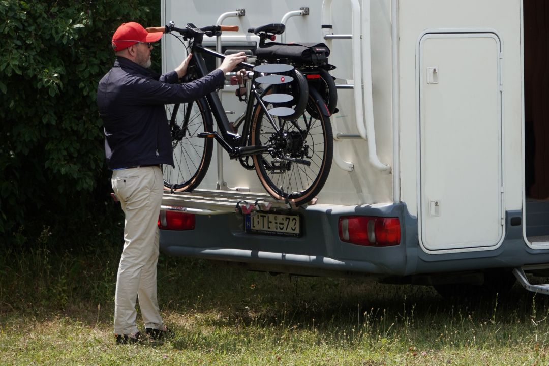 Fahrrad mit gefaltetem Pullit! auf dem Heckträger eines Wohnmobils